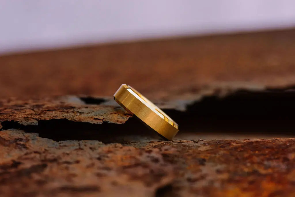 gold tungsten carbide ring on rustic backdrop