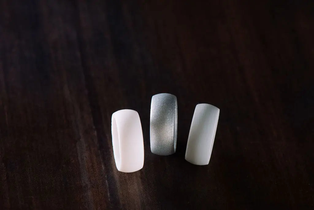 White and Silver Silicone Rings on Wood Backdrop