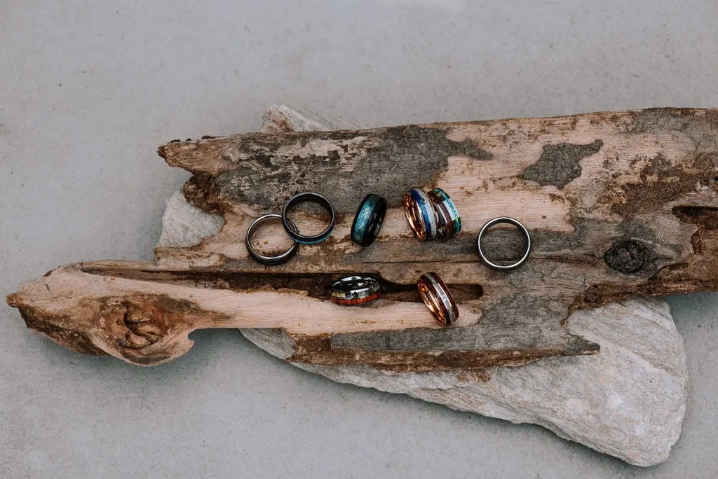 Bunch of Tungsten Carbide Rings laying on Piece of Wood
