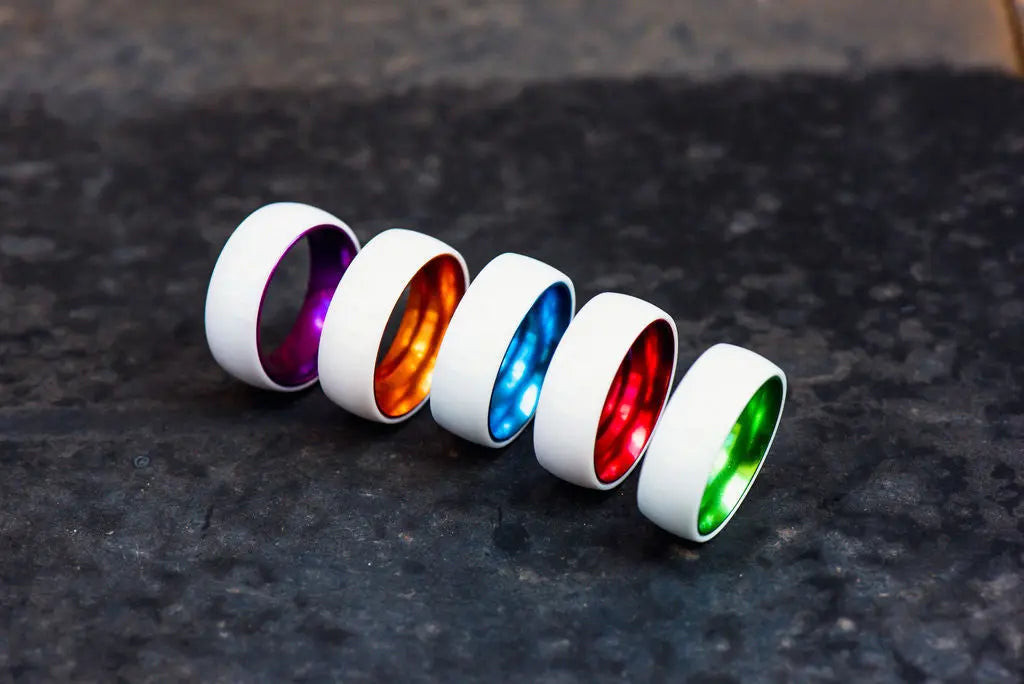 Row of Ceramic Rings with Different Colors on Dark Grey Backdrop
