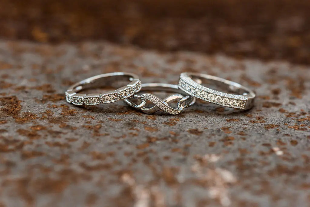 Three Sterling Silver Moissanite Rings on Rustic Backdrop
