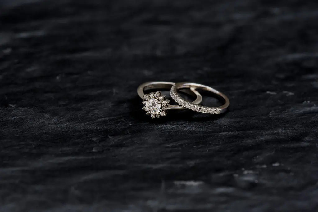 Two Moissanite Rings on Dark Charcoal Backdrop
