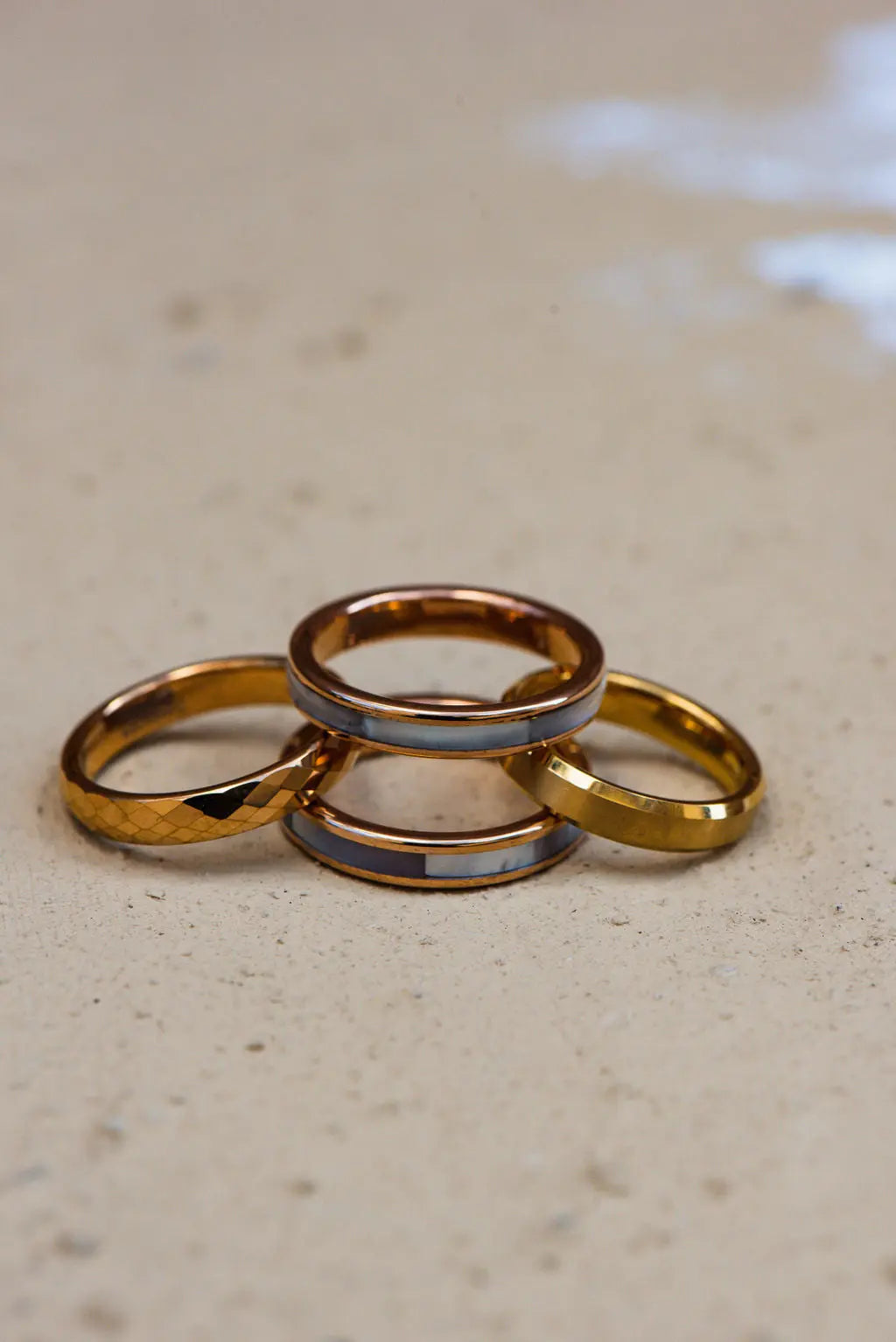 Four Gold Ladies Tungsten Carbide Rings Arranged on Neutral Backdrop