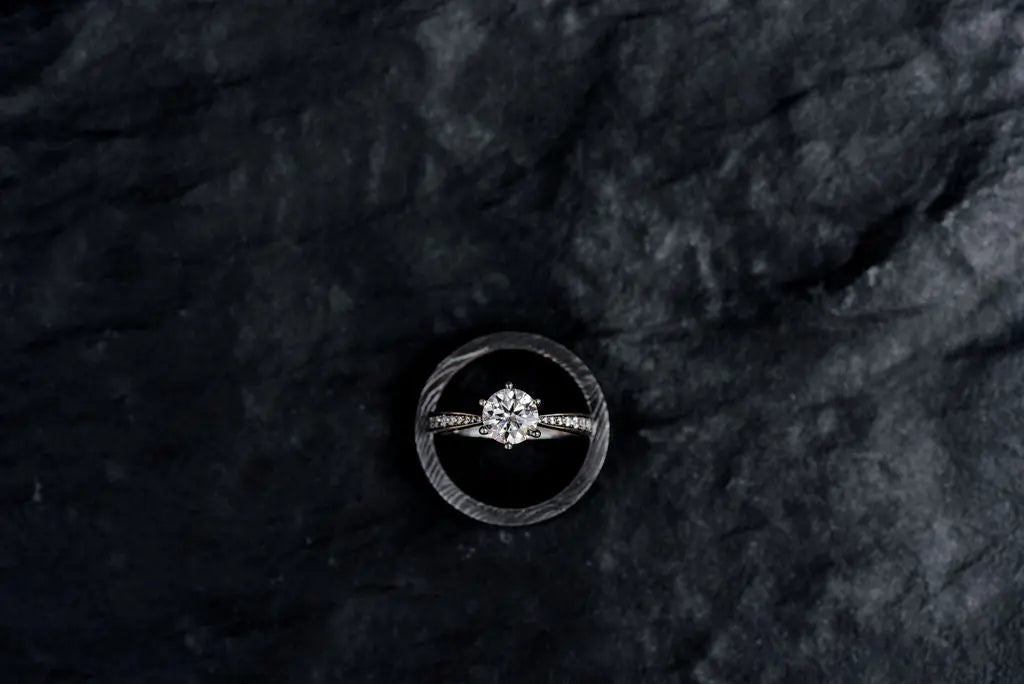 Two Moissanite Rings on Charcoal Backdrop
