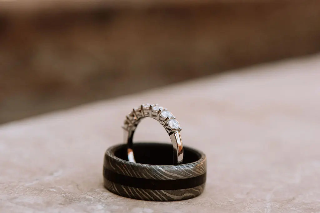 Sterling Silver Moissanite Ring Standing Inside Damascus Steel Ring