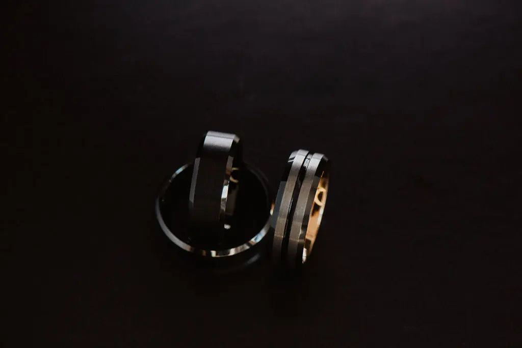 Three Black Tungsten Carbide Rings on Black Backdrop