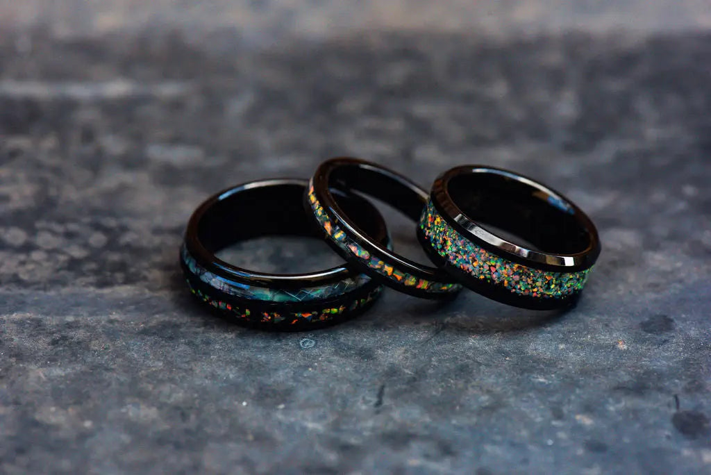 Three Tungsten Rings with Crushed Gemstone Inlays on White Backdrop