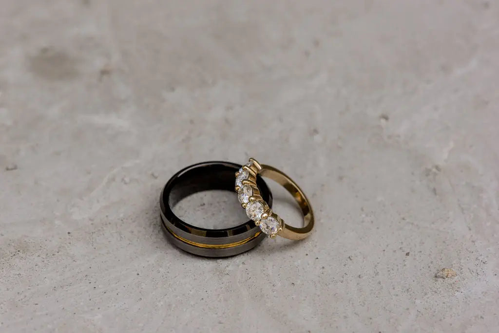 Two Wedding Rings With Gold Inlays on Neutral Backdrop