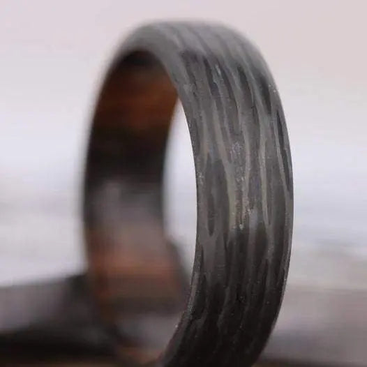 Zoomed view of mens wedding ring in carbon fibre and wood
